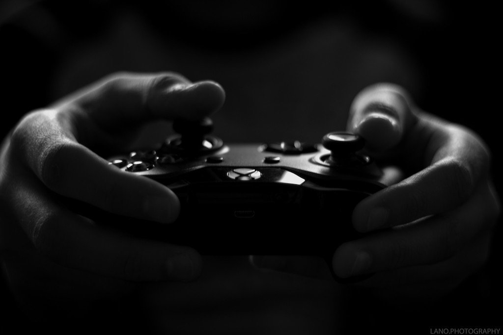 Person holding games controller - black and white