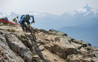 Mountain biker riding over rocks on a cliff edge