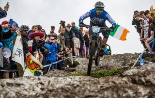 Team Chain Reaction Cyclist riding over rocks at mountain biking race